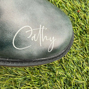 Mismatched Bronte Wuthering Heights boot  with 'Cathy' branding on grass